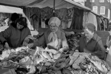853667 Afbeelding van enkele dames die tussen de kleding of lappen zoeken op de rommelmarkt in de Waterstraat te Utrecht.